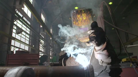 Welder in the Mask Welds the Pipe by Welding in the Factory Shop Vídeos de archivo 68507814