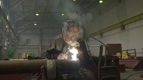 Welder in the Mask Welds the Pipe by Welding in the Factory Shop Stock Footage 68507838