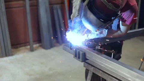 Welder or blacksmith, with his welder, welding steel and iron pipe profile Stock Footage 248714888