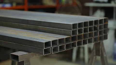Welder or blacksmith put metal iron square pipe profiles from warehouse Stock Footage 248714771