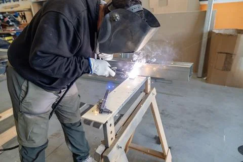 Welder performing metalwork using arc welding equipment Stock Photos