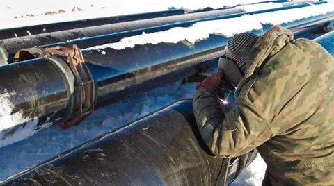 Welder performs welding pipeline in winter conditions Fotos de archivo