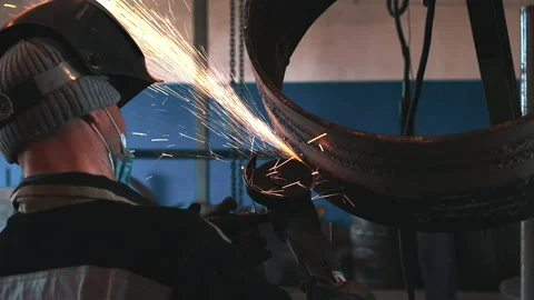 The welder processes the weld with a grinding machine and sparks fly. Processing Stock Footage 154903187