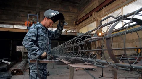 Welder professional cooks complex metal structures from fittings Stock Footage 135313103