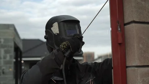 Welder in protective helmet uses welding. Welder Welds a metal pipe Video stock 263218657