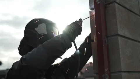 Welder in protective helmet uses welding. Welder Welds a metal pipe Video stock 263218683