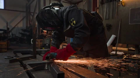 Welder in Protective Helmet Using Angle Grinder on Metal in Workshop Stock Footage 342503783