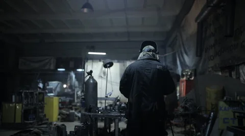 Welder in a protective helmet working on an industrial enterprise Stock Footage 60469656