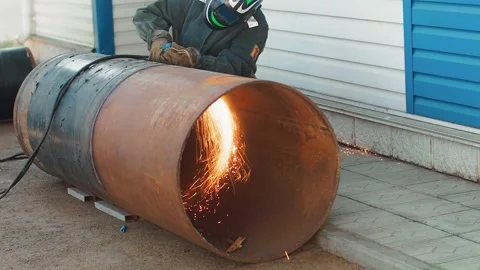 Welder in protective mask cuts large diameter pipe with autogenous gun from Stock Footage 248445385