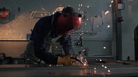 Welder in protective uniform working with lots of sparks in slow motion Video stock 265508020