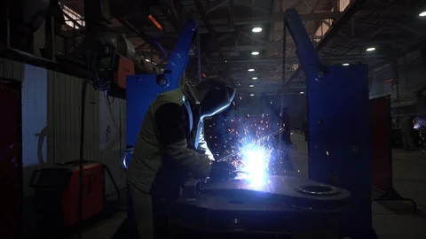 Welder in protective workwear at mechanical hangar.  Stock Footage