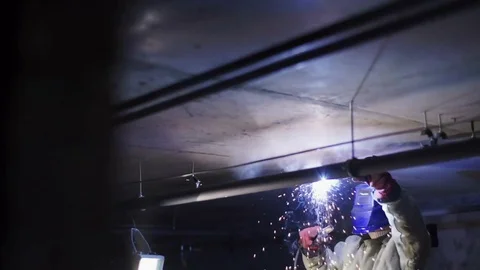 Welder puts on his face mask and welds pipes Stock Footage 82294634