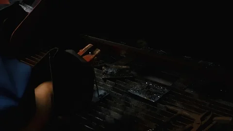 Welder scratching non-working stick electrode on a metal before weld spot Stock-Footage 102572131