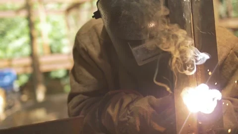 Welder training his dexterity on a piece of metal at a construction site Stock Footage 255684337