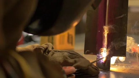 Welder training his dexterity on a piece of metal at a construction site Stock Footage 255684339
