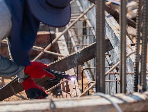 Welder using an electric arc welding torch to connect reinforcing steel bar.. Stock Photos