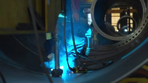 A welder is welding curved metal sheets together Stock Footage 283988076