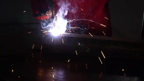 The welder is welding the iron in a low-light shop. Real sound included. Stock Footage 124416001