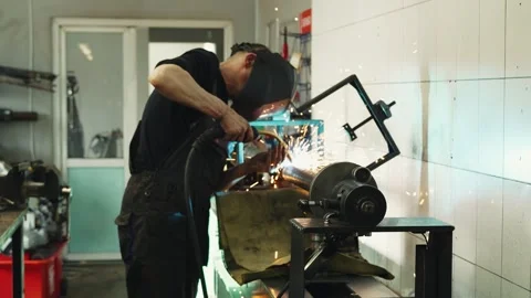 Welder in a welding mask performs welding work of a propeller shaft in a car Stock Footage 281581698