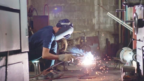 Welder is welding metal part in workshop factory Stock Footage 204055030