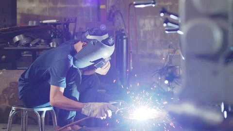 Welder is welding metal part in workshop factory Stock Footage 204055079