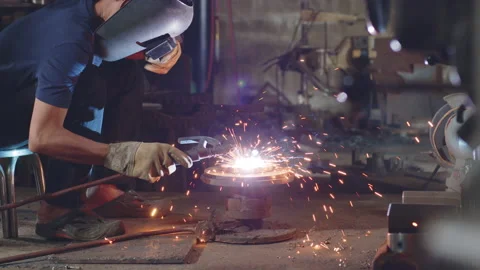 Welder is welding metal part in workshop factory Stock Footage 204055081