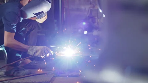 Welder is welding metal part in workshop factory Stock Footage 204055087