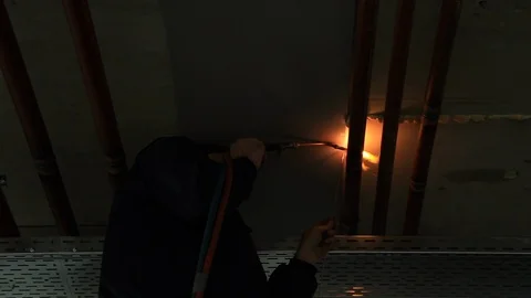 Welder Welding Pipes in the Ceiling of an Office under Construction Stock Footage 95908001