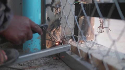 A welder is welding steel mesh without wearing gloves and eye protection Stock Footage 260518868