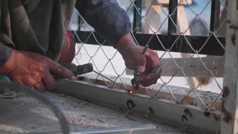 A welder is welding steel mesh without wearing gloves and eye protection Stock Footage 260518871