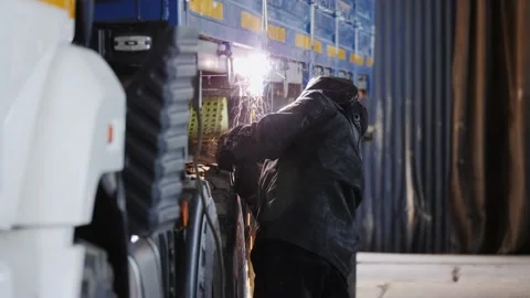 Welder welds a car trailer element Stock Footage 198146013