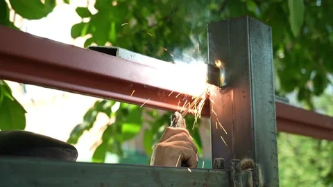 Welder Welds a metal pipe. Iron welding Stock Footage 259043353