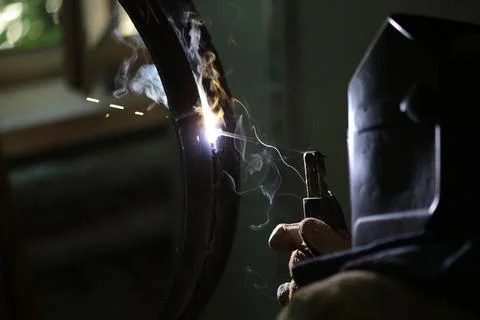 The welder welds the part Stock Photos