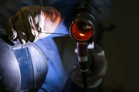 The welder welds a part using argon arc welding 스톡 사진