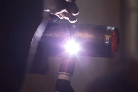 The welder welds a part using argon arc welding Stock Photos