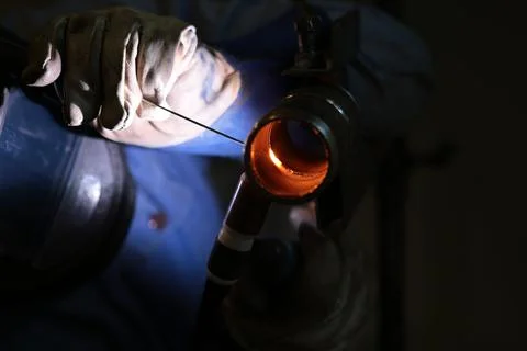 The welder welds a part using argon arc welding Stock Photos