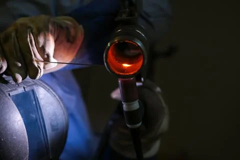 The welder welds a part using argon arc welding Stock Photos