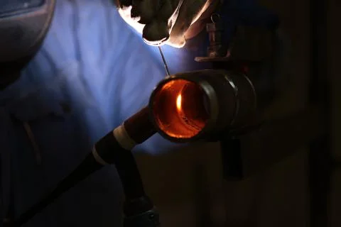 The welder welds a part using argon arc welding Stock Photos