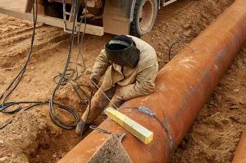 The welder welds the pipe by electro welding Stock Photos