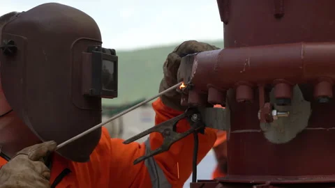 Welder welds. red vertical pipe. pipe repair. welding works Stock Footage 159911970