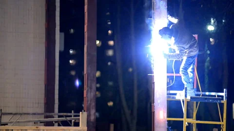 Welder welds structural beams on the scaffolding at night Stock Footage 46544486