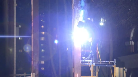 Welder welds structural beams on the scaffolding at night Stock Footage 46694229