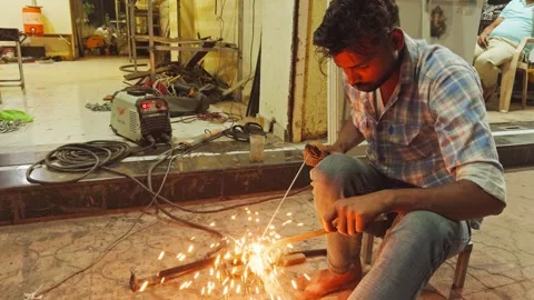 Welder at work with bright sparks in a workshop setting at night fabricatio.. Stock Footage 267852932
