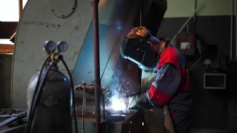 Welder at Work Creating Sparks in Industrial Workshop Video stock 306682162