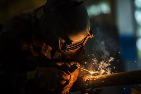 Welder at work. Man in a protective mask. The welder makes seams on the metal Foto stock