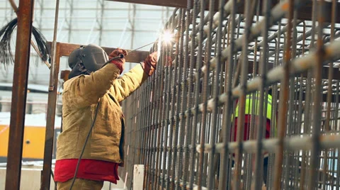 Welder at work, welding a metal framework pile Stock Footage 36297963