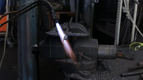 Welder at work. The worker heats the metal part with a gas welder Stock Footage 120112809