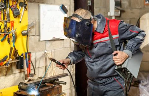 Welder worker in protective mask welding metal Stock Photos