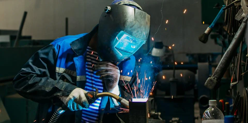 Welder working with electrode at semi-automatic arc welding. Stock Photos