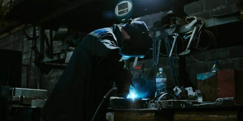 Welder working with electrode at semi-automatic arc welding. Stock Photos